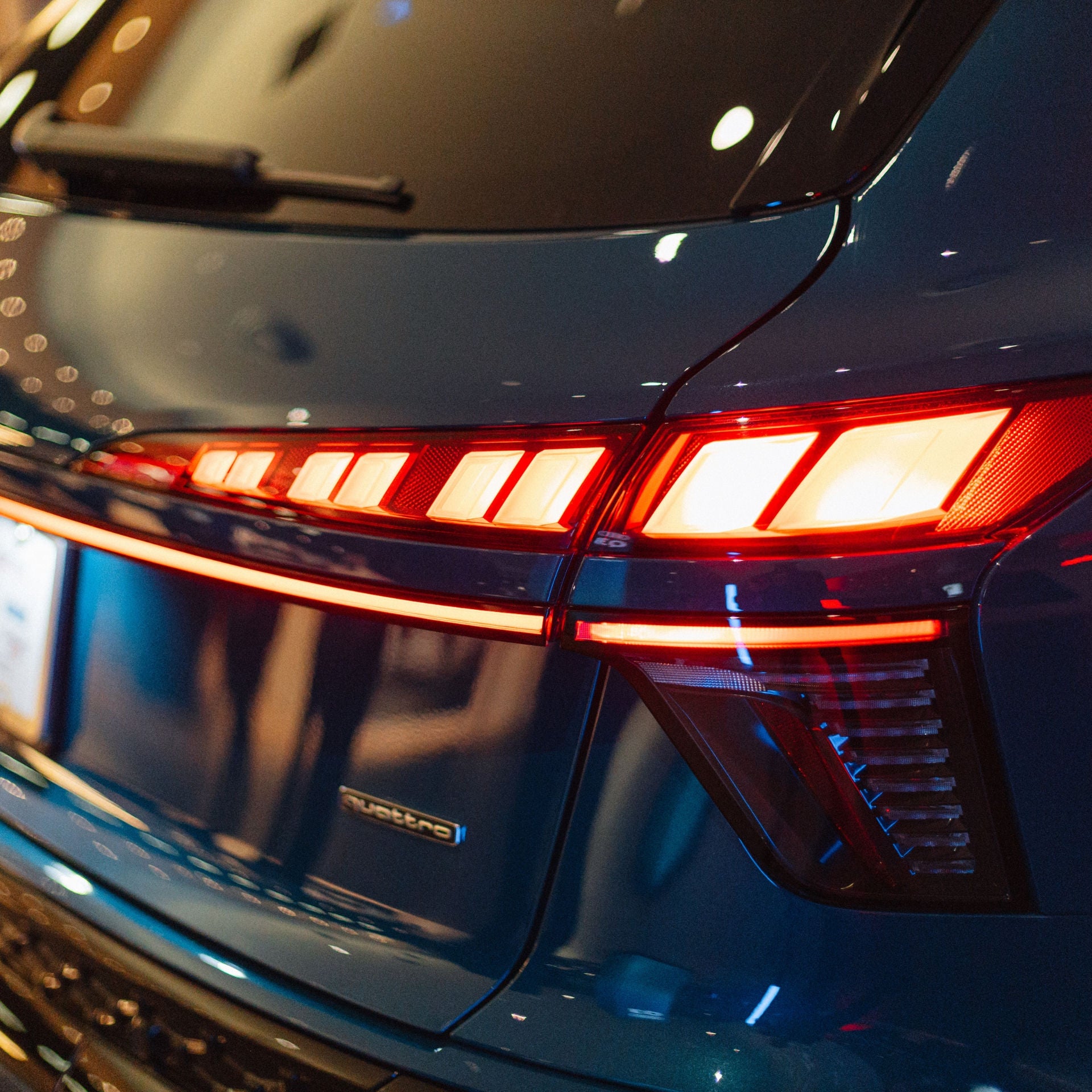 Rear view of a green Audi accelerating down the road. 